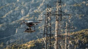 infra‑structure monitoring drone hovering near power‑lines or utility towers in greece mountainous region, technical inspection style, high vertical angle, professional.